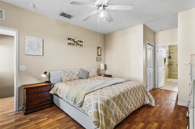 bedroom with connected bathroom, ceiling fan, and wood-type flooring