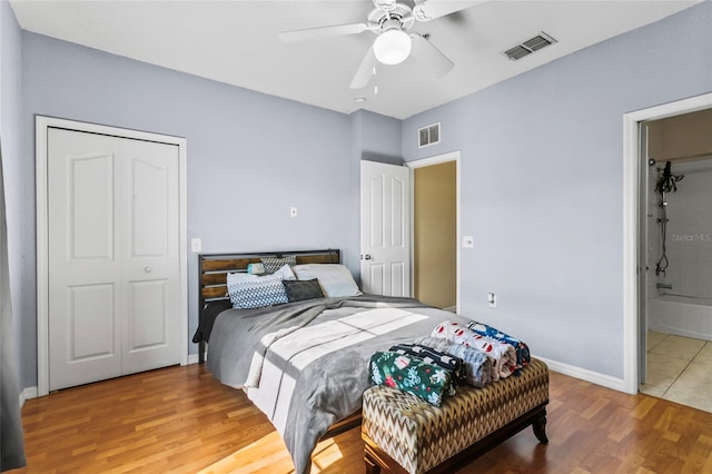 bedroom featuring connected bathroom, ceiling fan, a closet, and wood-type flooring