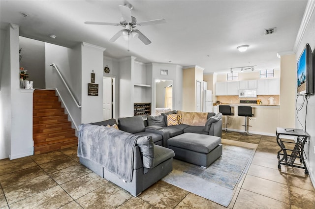 living room with ceiling fan and ornamental molding