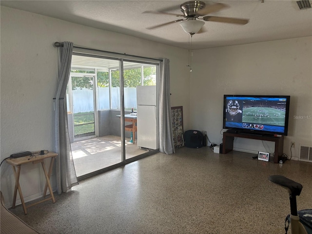 living room with a textured ceiling and ceiling fan