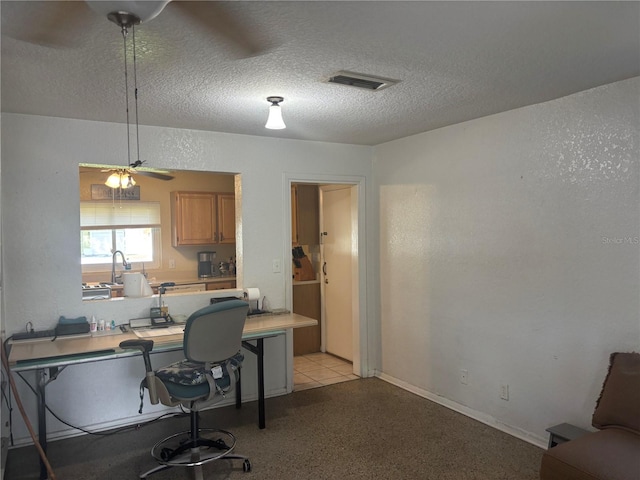 home office with a textured ceiling and ceiling fan