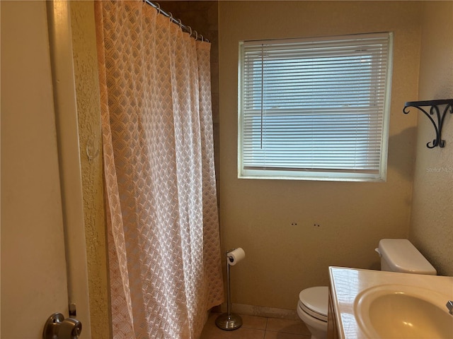 bathroom featuring toilet, plenty of natural light, sink, and tile patterned floors