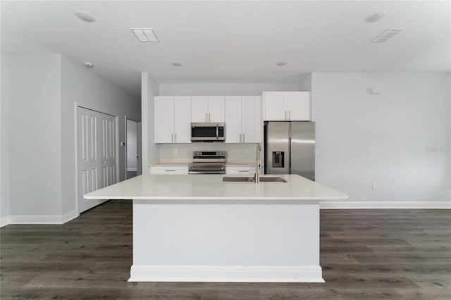 kitchen with an island with sink, appliances with stainless steel finishes, sink, and white cabinetry