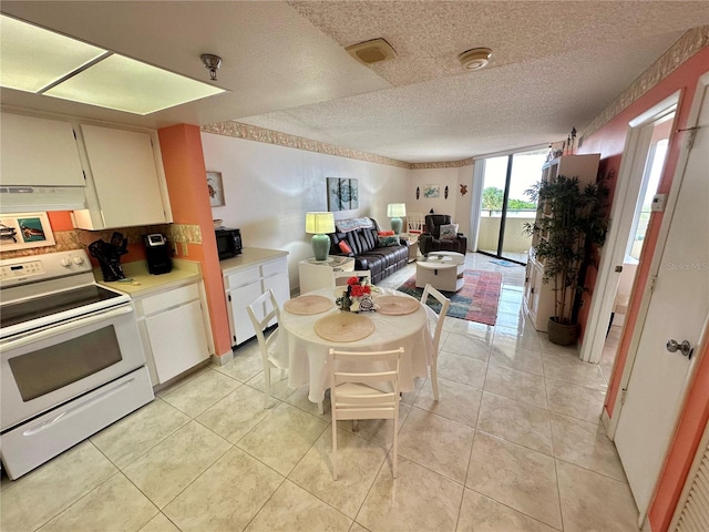 kitchen featuring a textured ceiling, extractor fan, decorative backsplash, light tile patterned floors, and white range with electric stovetop