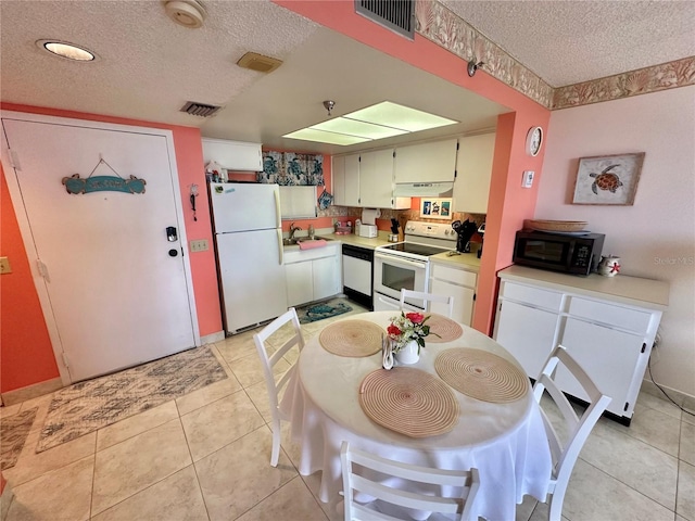 tiled dining area with a textured ceiling and sink