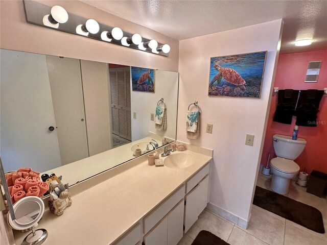 bathroom with tile patterned floors, a textured ceiling, vanity, and toilet