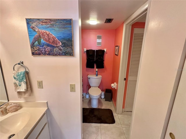 bathroom with tile patterned flooring, a textured ceiling, vanity, and toilet