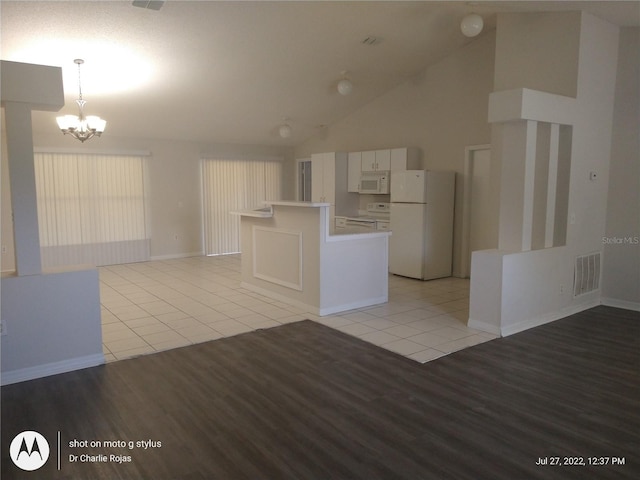 interior space featuring a chandelier, light hardwood / wood-style flooring, and high vaulted ceiling