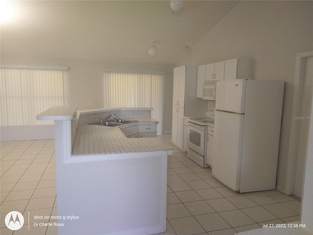 kitchen featuring light tile patterned flooring, sink, lofted ceiling, white cabinetry, and white appliances