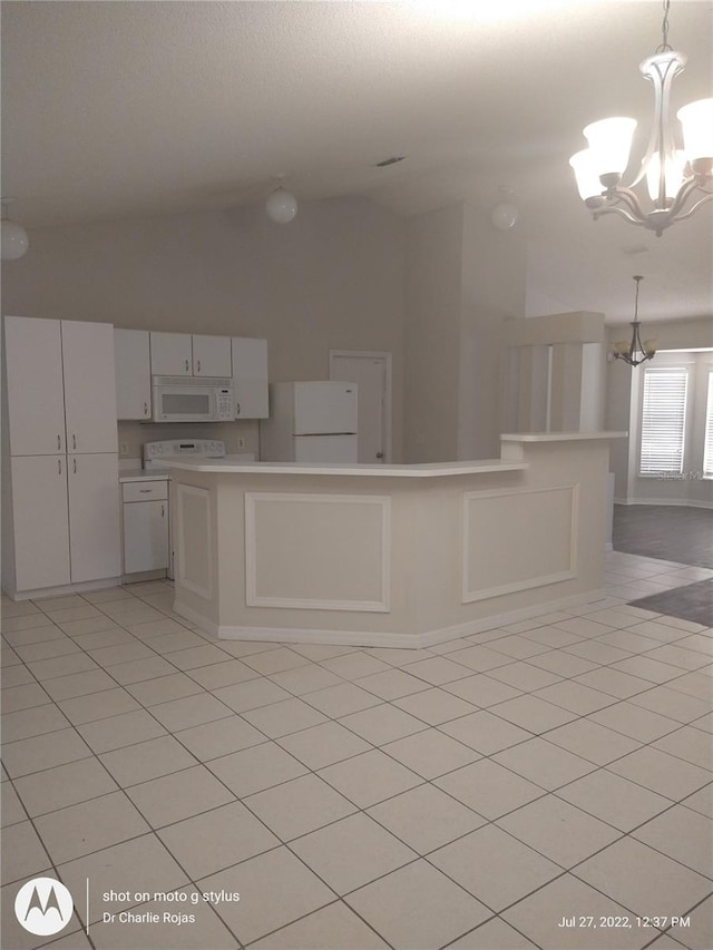 kitchen with vaulted ceiling, white cabinetry, white appliances, pendant lighting, and an inviting chandelier