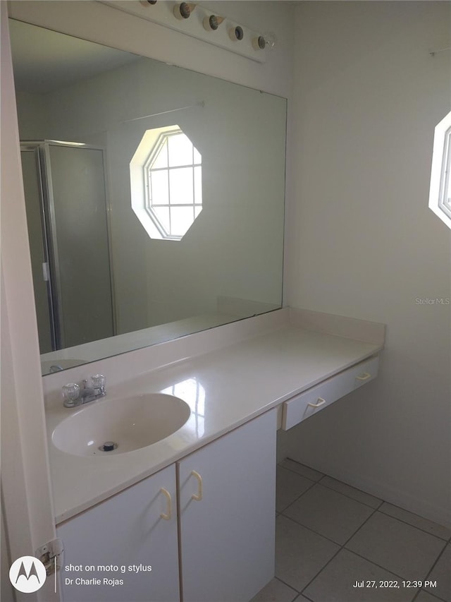 bathroom featuring vanity, a shower with door, and tile patterned floors