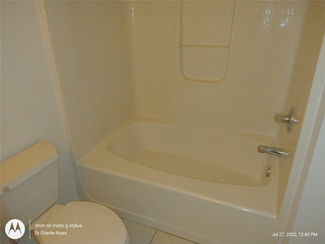 bathroom featuring bathing tub / shower combination, tile patterned floors, and toilet