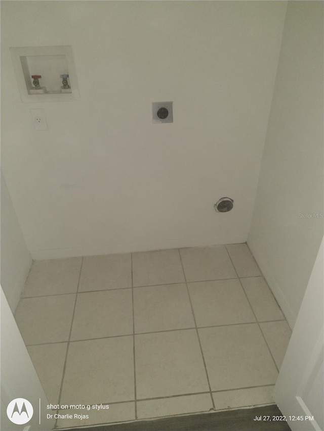 laundry area with hookup for a washing machine, hookup for an electric dryer, and light tile patterned floors