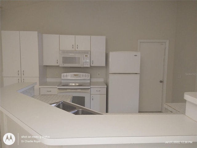 kitchen featuring sink, white appliances, and white cabinetry