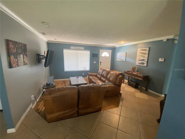 living area with a textured ceiling, crown molding, and baseboards