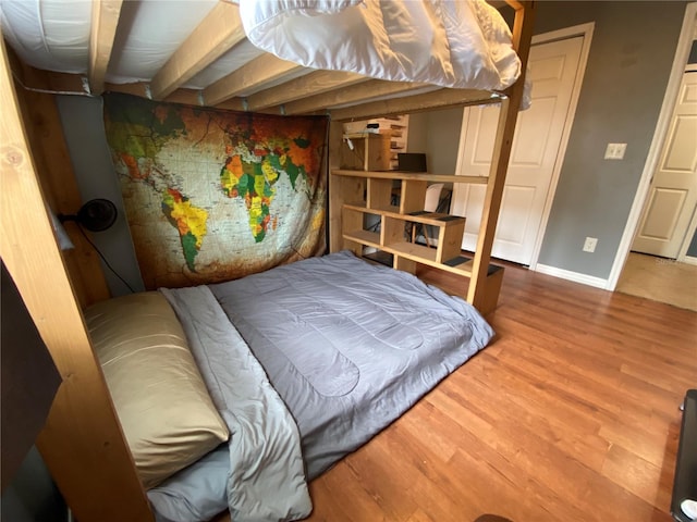 bedroom featuring baseboards and wood finished floors