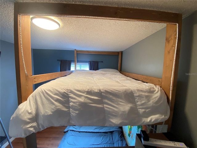 bedroom with wood finished floors and a textured ceiling