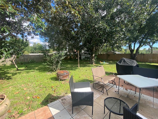view of yard with a fire pit, a patio, and a fenced backyard