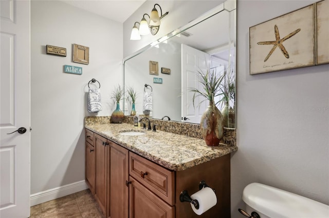 bathroom with vanity, tile patterned flooring, and toilet