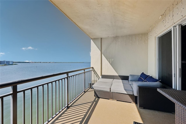 balcony with a water view and an outdoor living space