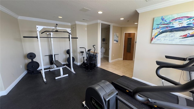 workout area featuring ornamental molding and a textured ceiling