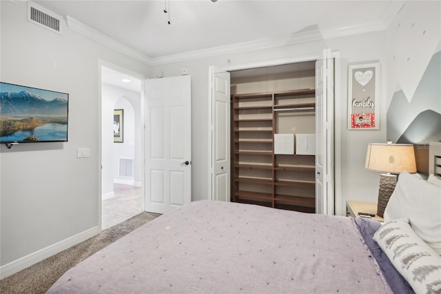 carpeted bedroom with a closet and crown molding