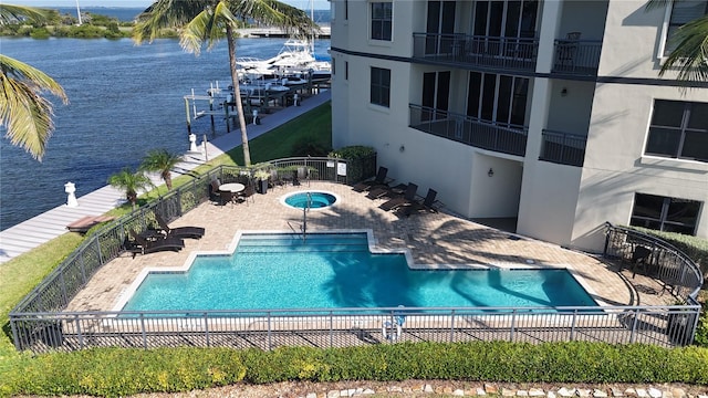 view of swimming pool with a patio and a water view