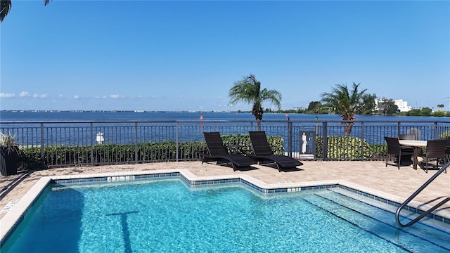 view of swimming pool featuring a water view and a patio area