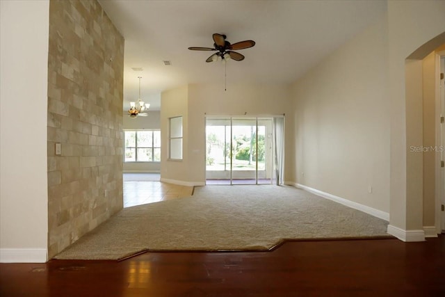 3757 Eagle Isle Cir, Kissimmee, FL 34746 - unfurnished living room featuring ceiling fan with notable chandelier, arched walkways, carpet floors, and baseboards