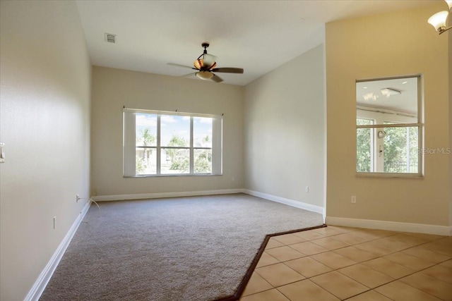 tiled empty room featuring lofted ceiling and ceiling fan