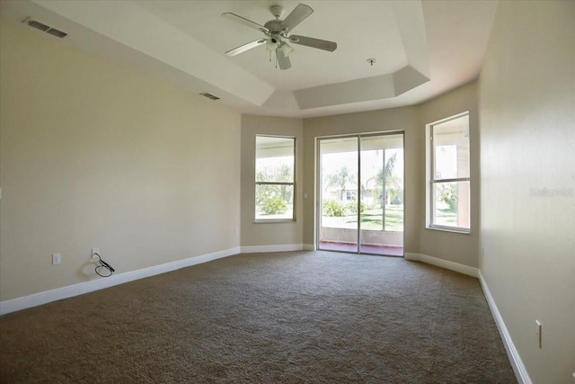 3757 Eagle Isle Cir, Kissimmee, FL 34746 - unfurnished room featuring baseboards, visible vents, dark colored carpet, and a raised ceiling
