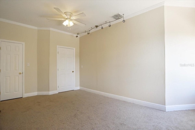 carpeted spare room featuring ceiling fan and crown molding