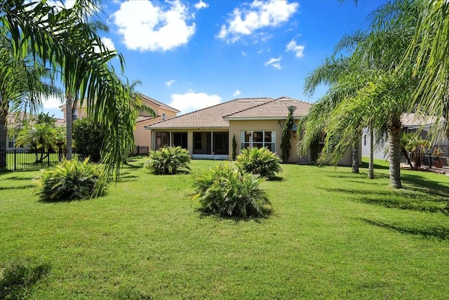 3757 Eagle Isle Cir, Kissimmee, FL 34746 - back of house with a tile roof, fence, stucco siding, and a yard
