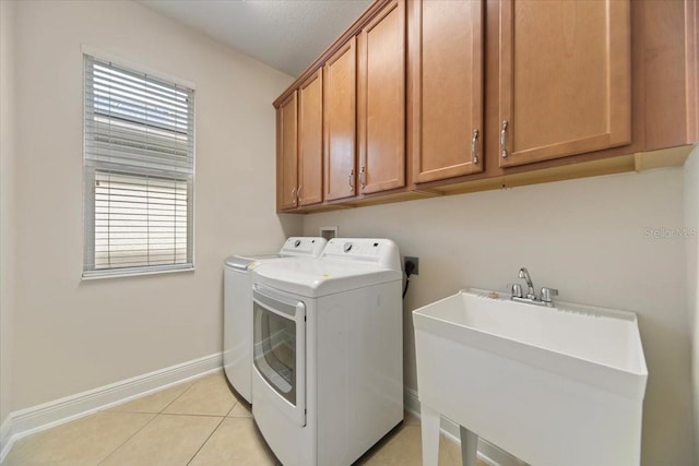 laundry area with cabinets, separate washer and dryer, sink, and plenty of natural light