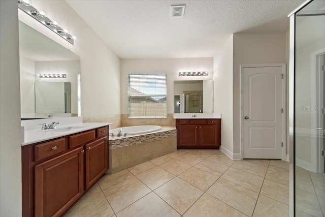 bathroom featuring vanity, tile patterned flooring, separate shower and tub, and a textured ceiling