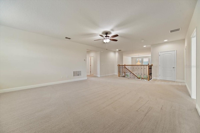 carpeted empty room featuring ceiling fan and a textured ceiling