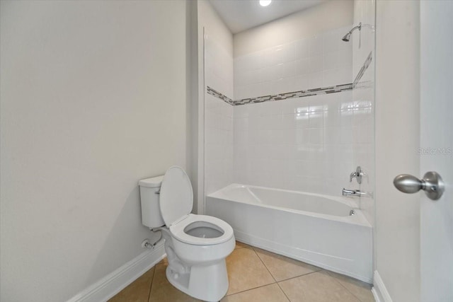 bathroom featuring tiled shower / bath combo, tile patterned flooring, and toilet