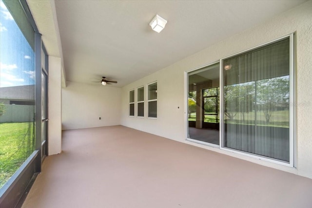 unfurnished sunroom with ceiling fan