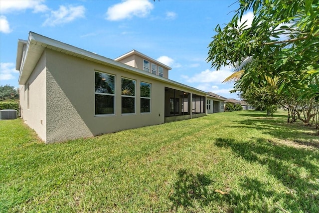 back of property with a sunroom, cooling unit, and a yard