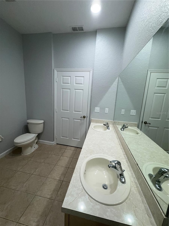 bathroom with tile patterned flooring, vanity, and toilet