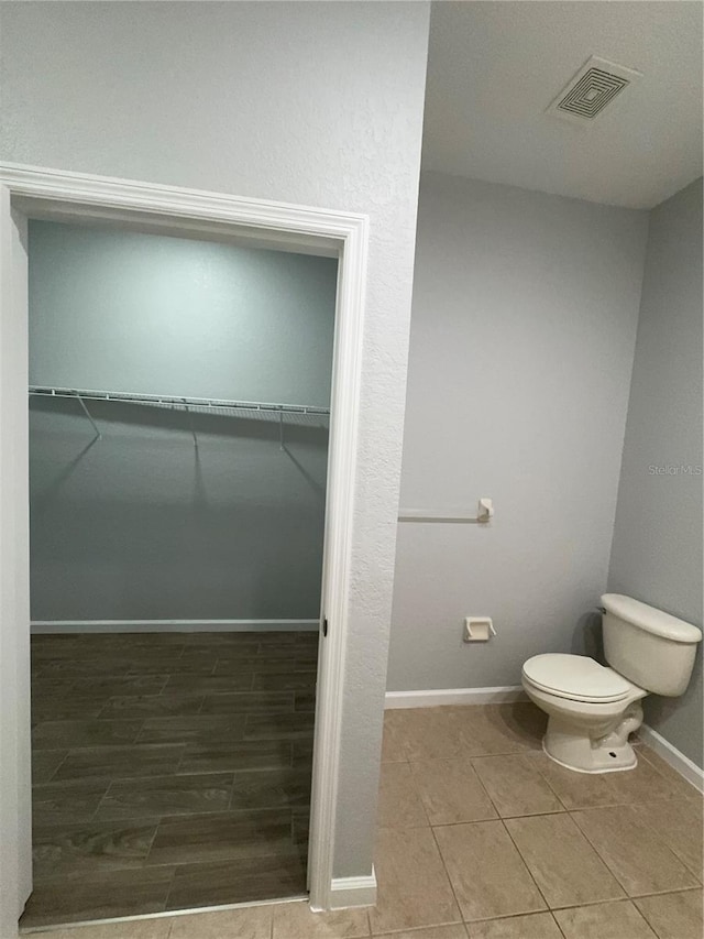 bathroom with hardwood / wood-style floors and toilet