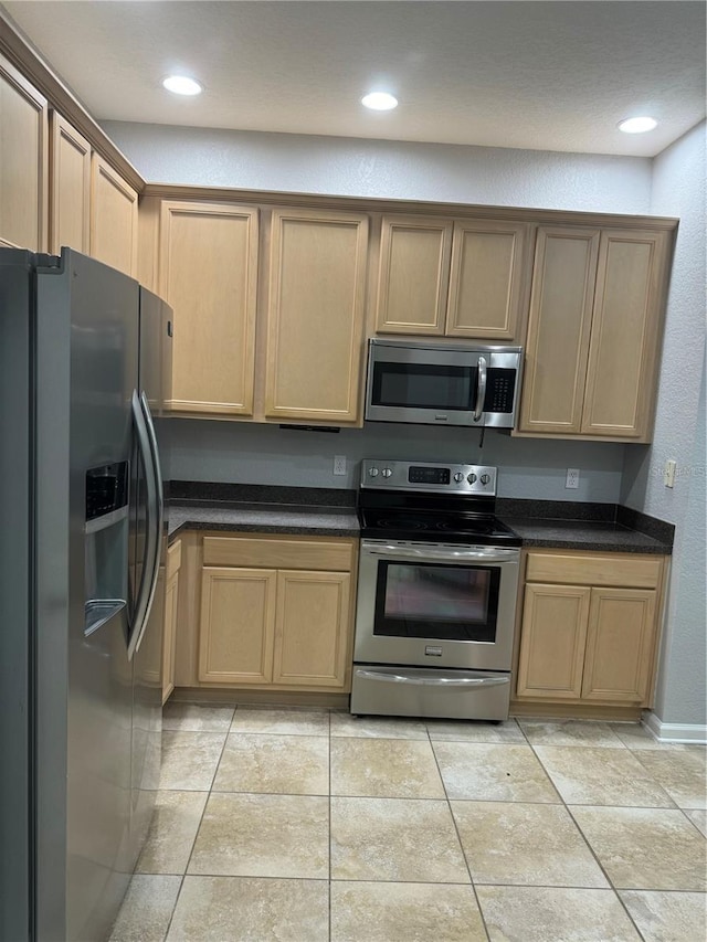 kitchen featuring stainless steel appliances and dark stone countertops