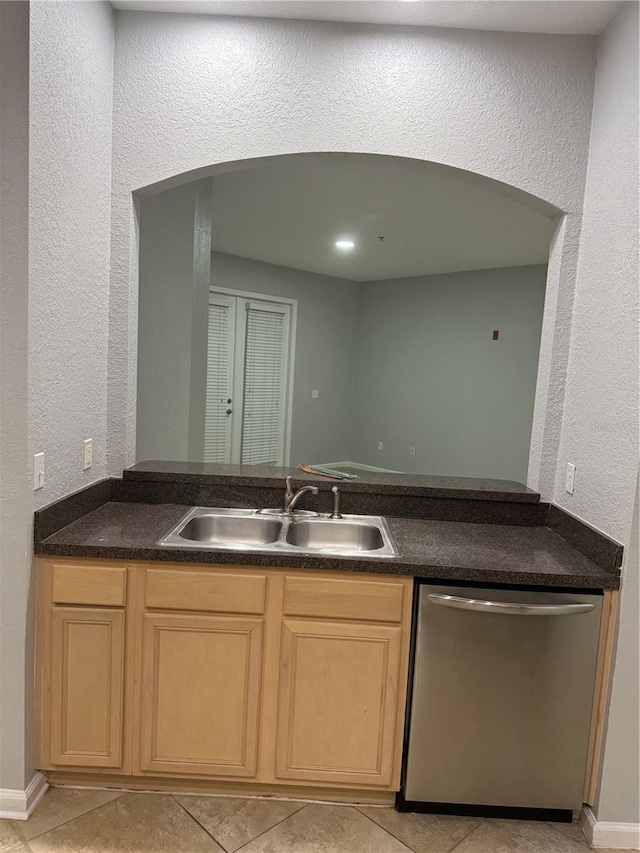 kitchen featuring light tile patterned floors, light brown cabinets, sink, and stainless steel dishwasher