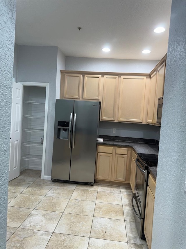 kitchen with black appliances, light brown cabinets, and light tile patterned floors