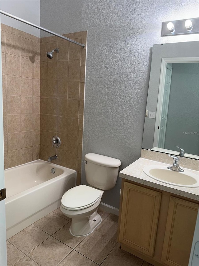 full bathroom with tiled shower / bath combo, tile patterned flooring, vanity, and toilet