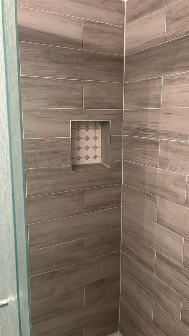 interior details featuring a tile shower