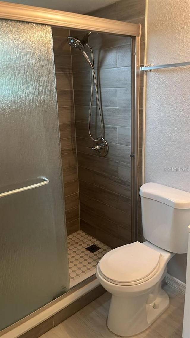 bathroom with an enclosed shower and toilet