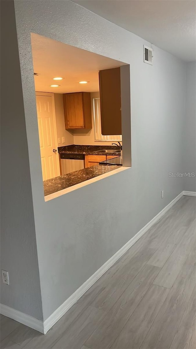 kitchen featuring dishwasher, sink, and hardwood / wood-style flooring