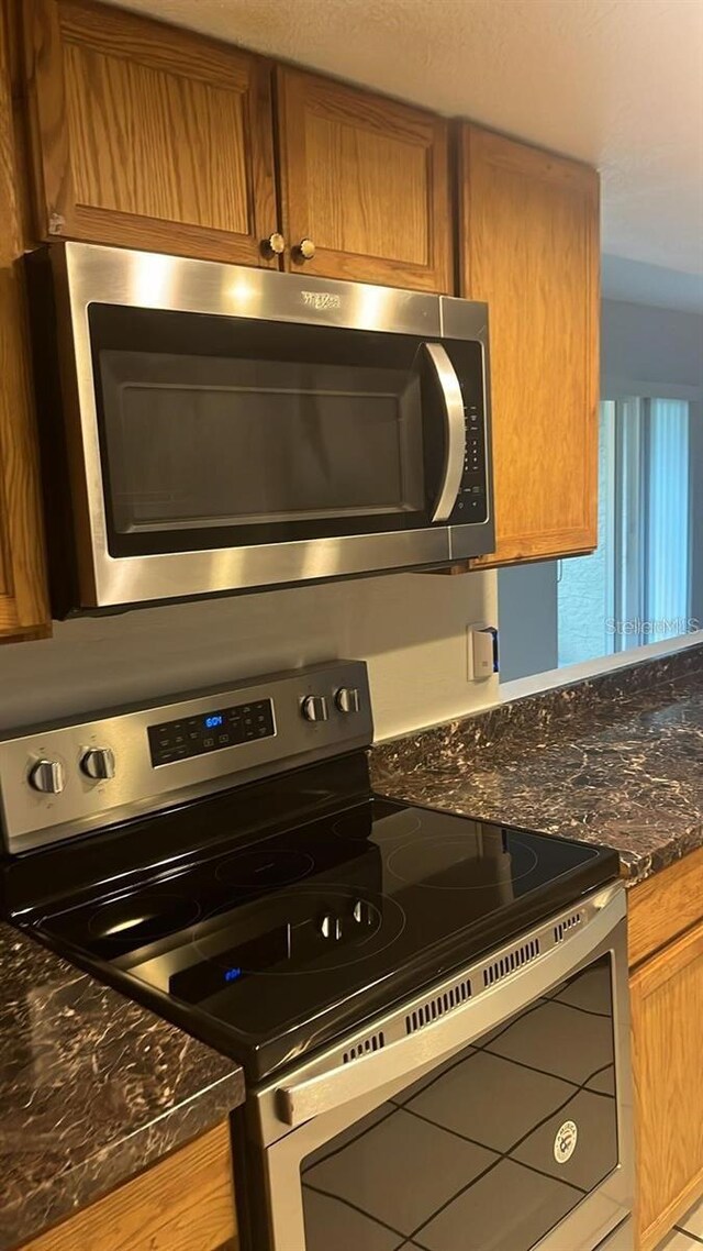 kitchen featuring dark stone countertops and stainless steel appliances