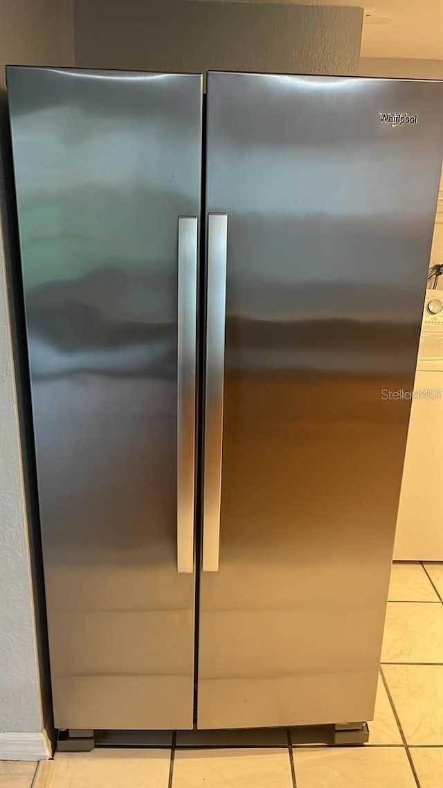 interior details with stainless steel refrigerator and light tile patterned flooring